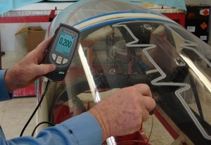 Technician measuring remaining thickness of an aircraft window